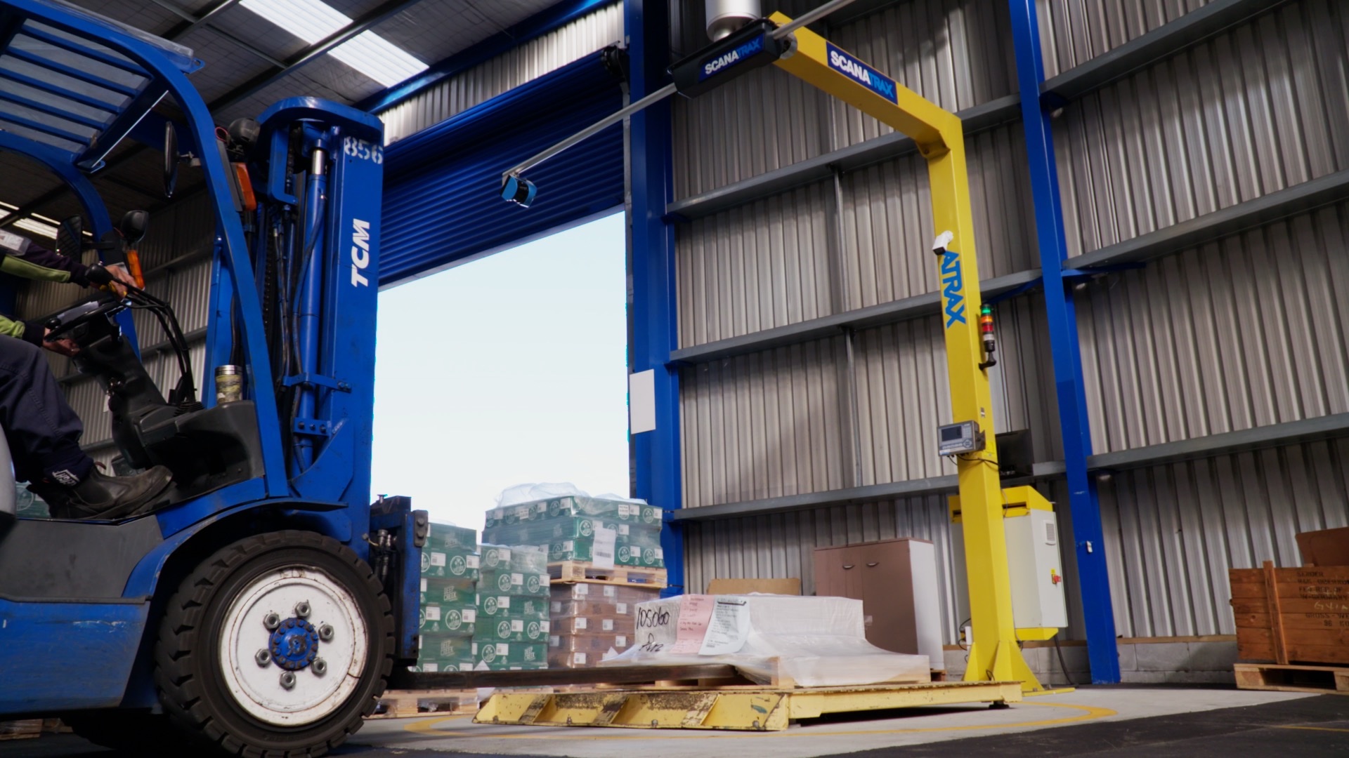 Forklift dropping a pallet under the Scanatrax arm